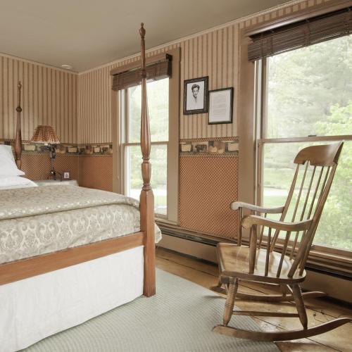 a bedroom with a bed and a rocking chair at Golden Stage Inn in Proctorsville