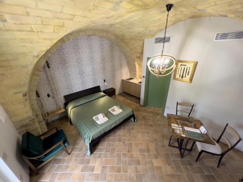 a bedroom with a bed and a table and a chair at Relais Cocci Grifoni - Panoramic Wine Resort in Offida