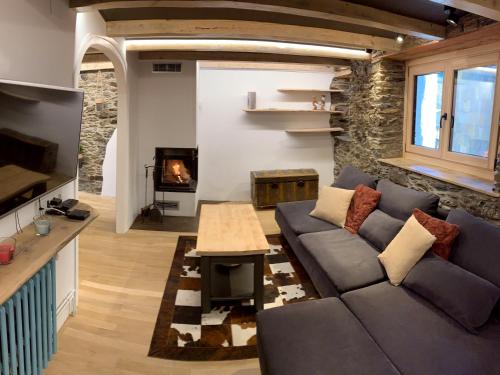 sala de estar con sofá y chimenea en Cal Potablanc, en Canillo