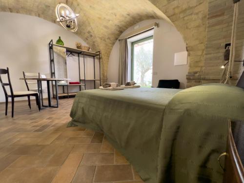 a bedroom with a large bed in a room with a table at Relais Cocci Grifoni - Panoramic Wine Resort in Offida