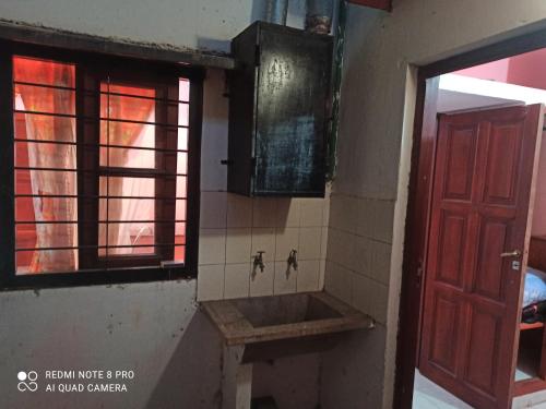 Un baño con lavabo y puerta roja. en Hospedaje El Turista., en Libertador General San Martín