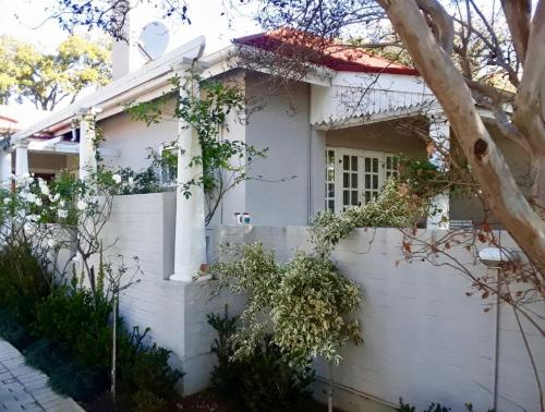 a white house with a white fence at Middelberg Manor in Pretoria