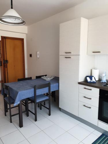 uma cozinha com uma mesa azul e cadeiras em Baia Alcantara Apartments (Old Bay Group) em Giardini Naxos