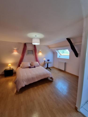 Schlafzimmer mit einem Bett und einem Fenster in der Unterkunft Chambre Matisse - Closeries du Golfe in Theix