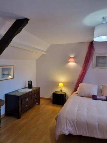 ein Schlafzimmer mit einem Bett und eine Kommode mit einer Lampe in der Unterkunft Chambre Matisse - Closeries du Golfe in Theix