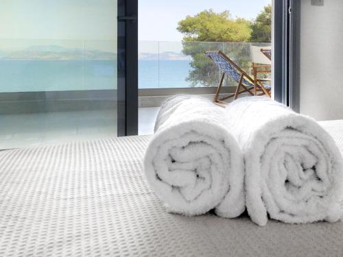 a white towel on a bed in front of a window at Anavalos in Kivérion