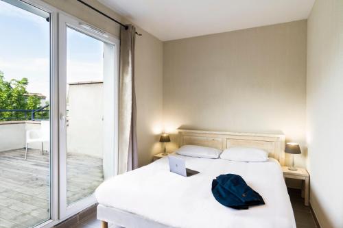 a bedroom with a bed with a laptop on it at Garden & City Mont-Ventoux Malaucène in Malaucène