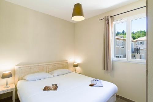 a bedroom with a white bed with a window at Garden & City Mont-Ventoux Malaucène in Malaucène
