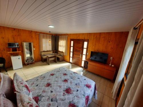 a bedroom with a bed and a television in it at Cânions de Cambará in Cambara do Sul