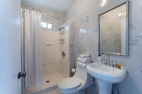 La salle de bains est pourvue d'un lavabo, de toilettes et d'une douche. dans l'établissement Normandie Manor, à Los Angeles