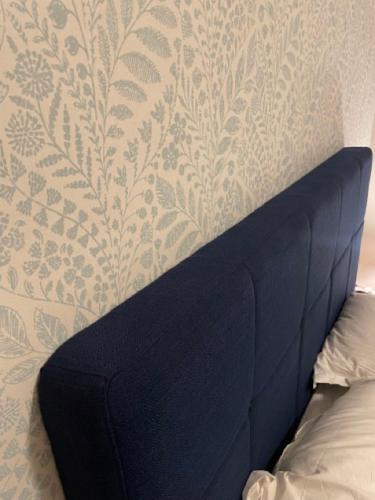 a bed against a wall with a patterned wallpaper at L'Adrion in Draguignan