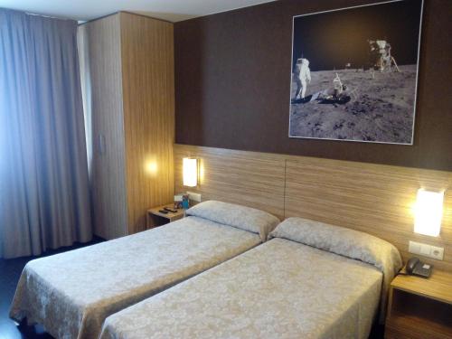 a hotel room with two beds and two lamps at Hotel Moon in A Coruña