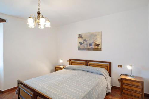 - une chambre avec un lit et un lustre dans l'établissement Il piccolo fienile, à Vessalico