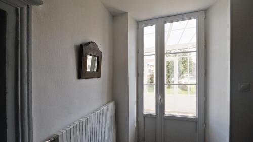 a hallway with a door and a window at Le chat Moustic in Rarécourt