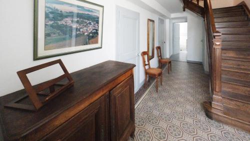 a hallway with a wooden desk and a chair at Le chat Moustic in Rarécourt
