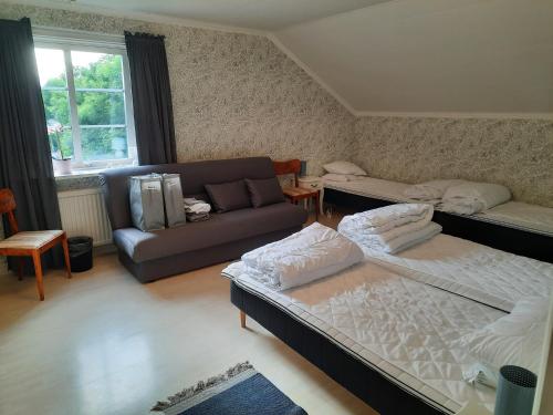 uma sala de estar com duas camas e um sofá em Sjötorp Säteri Bed & Breakfast em Larv