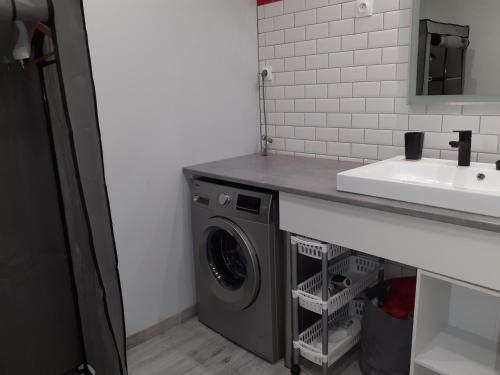 - une buanderie avec un évier et un lave-linge dans l'établissement charmant studio équipé au cœur du village, à Valleraugue