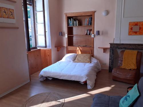 une chambre avec un lit et une chaise dedans dans l'établissement charmant studio équipé au cœur du village, à Valleraugue