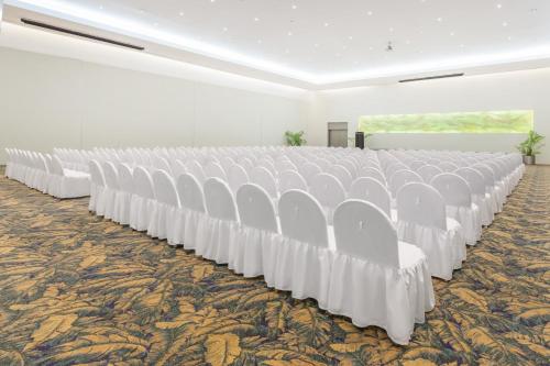 a row of white chairs in a white room at Gamma Colima Garden in Colima