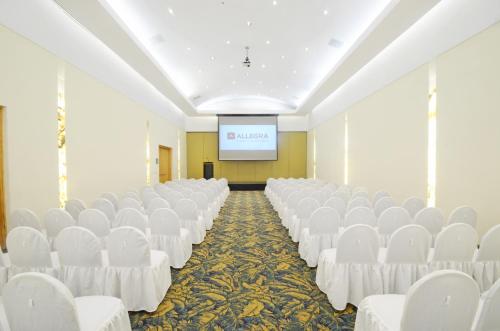 a lecture hall with white chairs and a screen at Gamma Colima Garden in Colima