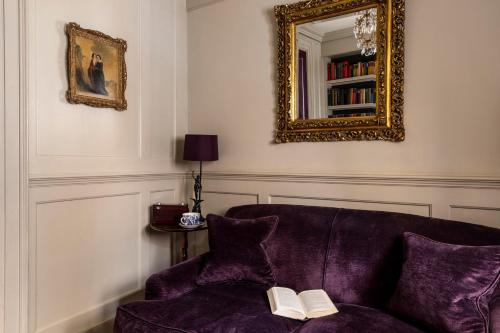 a living room with a purple couch and a mirror at Hazlitt's in London