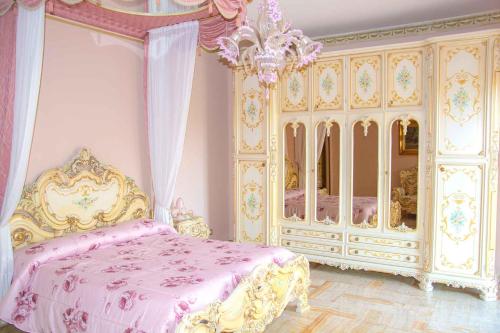um quarto rosa e dourado com uma cama e uma cómoda em Colazione da Tiffany - Villa Bei Ricordi - B&B - Spa privata em Santa Lucia di Serino