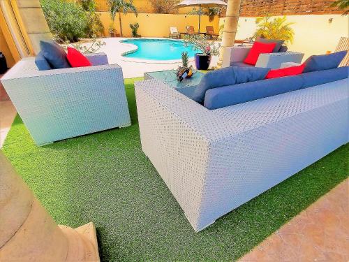 dos sofás azules y rojos sentados junto a una piscina en Spacious Villa with Ocean and Mountain view-4 beds en Cul de Sac