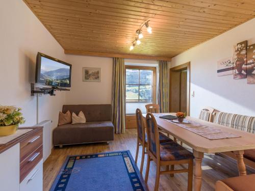a kitchen and living room with a table and a couch at Ferienwohnungen Rieser in Hainzenberg