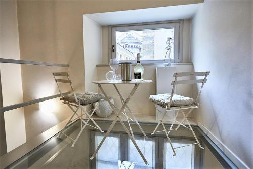 two chairs and a table in a room with a window at ASTRA-Modern Loft Cathedral View in Bergamo