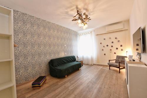 - un salon avec un canapé vert et un mur dans l'établissement Al Piano - home away from home, à Venise