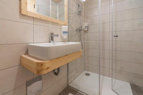 a bathroom with a sink and a shower at Planinska koča na Uskovnici in Srednja Vas v Bohinju