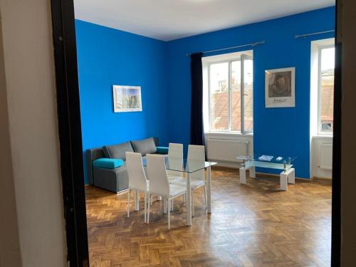 ein blaues Wohnzimmer mit einem Tisch und einem Sofa in der Unterkunft Virmenski sobor apt high ceiling,not attic in Lwiw