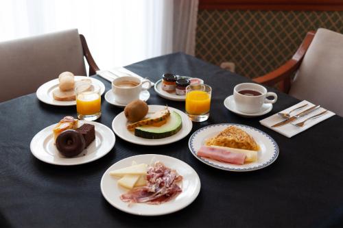 a table topped with plates of food and drinks at Hotel Hoyuela in Santander
