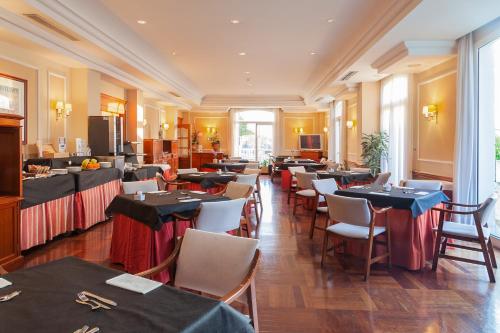 a restaurant with tables and chairs in a room at Hotel Hoyuela in Santander