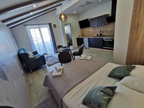 a bedroom with a large bed and a kitchen at New Nikolina 4 star in Mali Lošinj