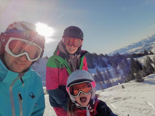 a group of three people standing on a ski slope at Bergzeit - Hotel & Appartements in Oberjoch