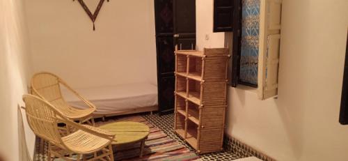 a room with two chairs and a table and shelves at Riad TaTam House in Marrakech