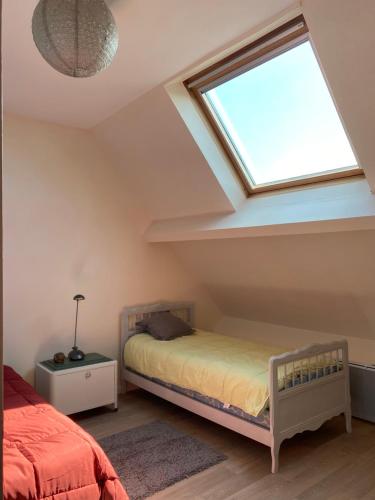 a attic bedroom with a bed and a skylight at Villa Lou Marjentin in Wimereux