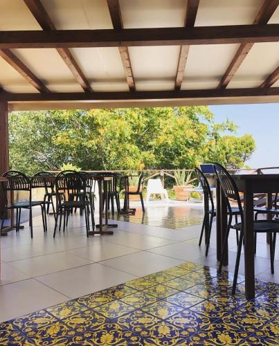 a dining room with tables and chairs on a patio at B&B Alfrantoio Valderice in Valderice