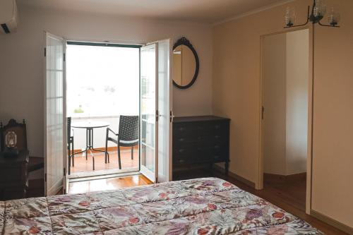 a bedroom with a bed and a sliding glass door at Casal dos Cantos in Quinta do Anjo
