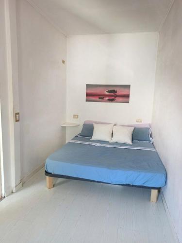 - une chambre dotée d'un lit bleu et d'une peinture murale dans l'établissement Casa La Gardenia, à Torre del Lago Puccini