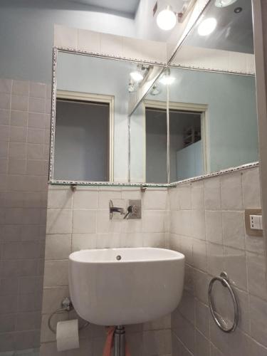 La salle de bains est pourvue d'un lavabo blanc et d'un miroir. dans l'établissement Casa La Gardenia, à Torre del Lago Puccini