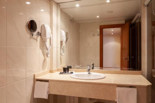 a bathroom with a sink and a mirror at Hotel Hoyuela in Santander