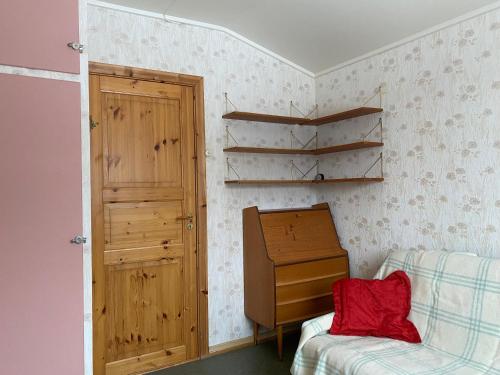 a room with a bed and a dresser and a door at Koselig hus med parkeringsplass in Skaland
