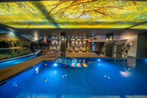 a swimming pool in a house with a ceiling at Złoty Groń Resort & Spa in Istebna