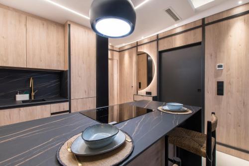 uma cozinha com uma mesa com dois pratos em JUAN BRAVO Apartamento a estrenar con PISCINA em Madrid