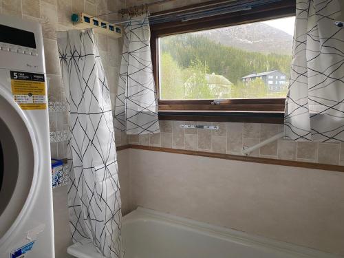 a bathroom with a window and a washing machine at Koselig hus med parkeringsplass in Skaland