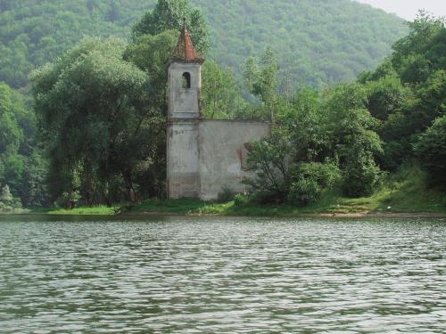 an old building on the side of a body of water at Cincis by the Lake in Cinciş