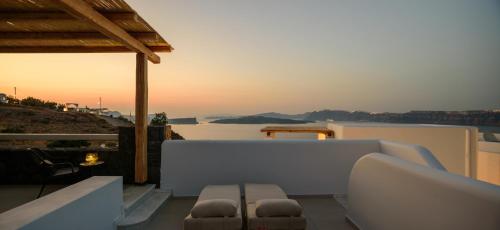 a balcony with a view of the ocean at sunset at Acro Blue Luxury Villas in Akrotiri