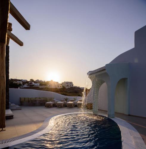 a pool on the roof of a building with a fountain at Acro Blue Luxury Villas in Akrotiri